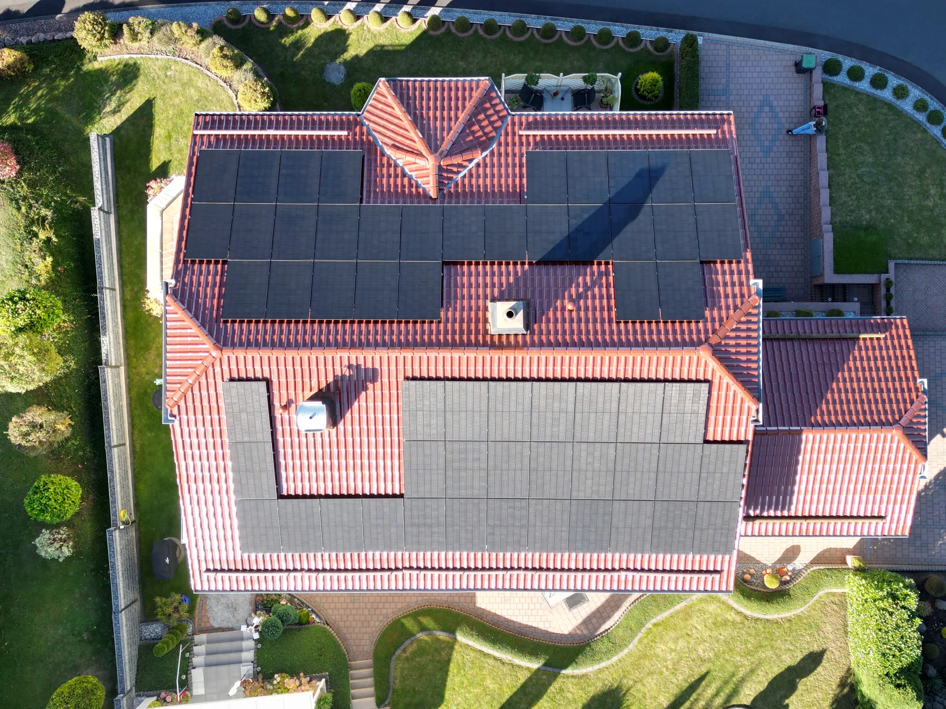 Luftaufnahme eines Hausdachs mit schwarzen Solarmodulen