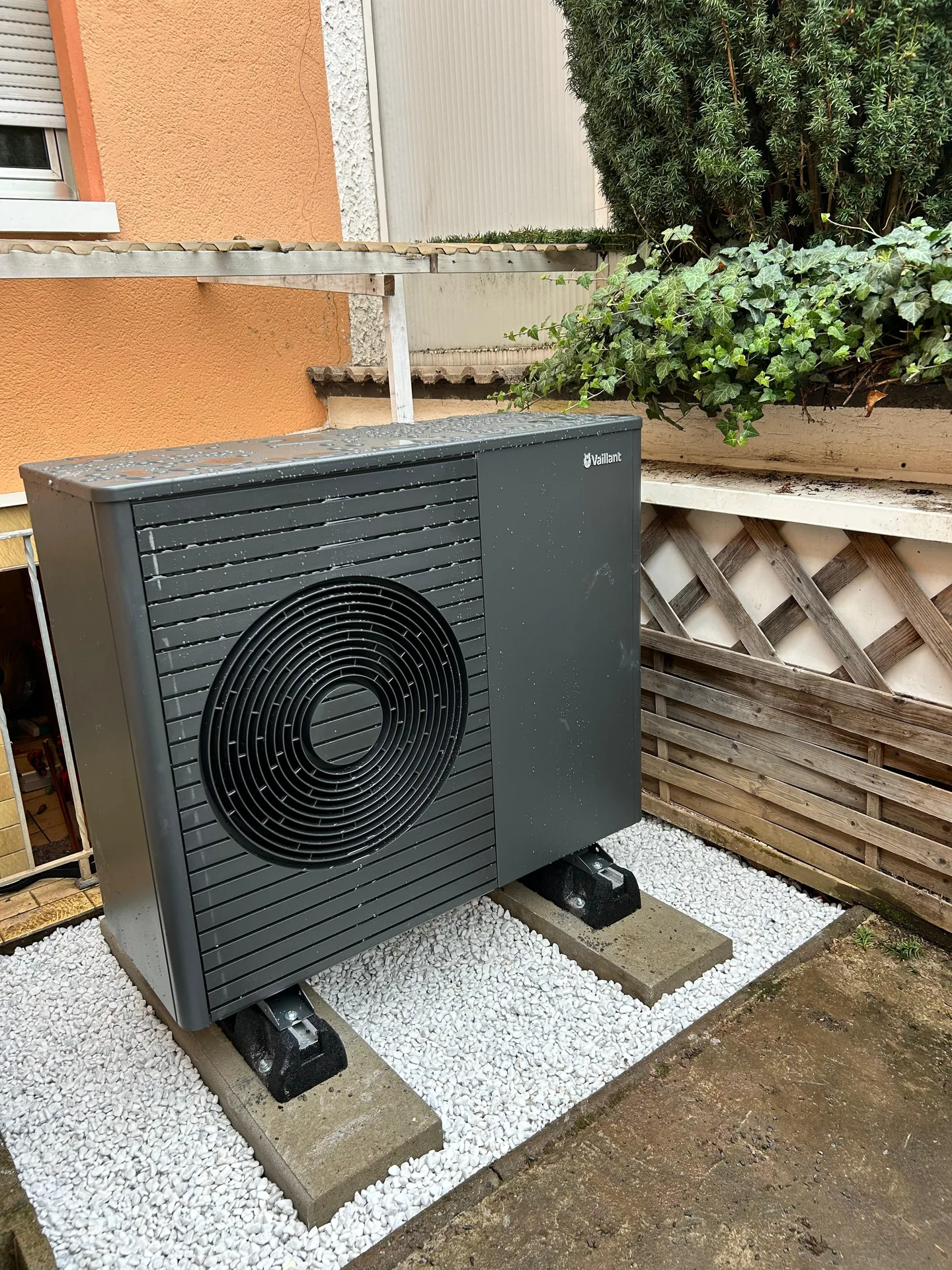 Vaillant-Wärmepumpe im aktuellen dunklen Gehäuse, Außeneinheit auf Betonsockel
