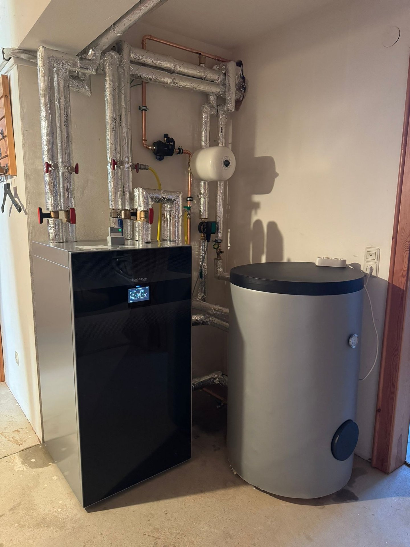 Buderus Wärmepumpe und Pufferspeicher im Heizungskeller — installiert von Thiessen Energy
